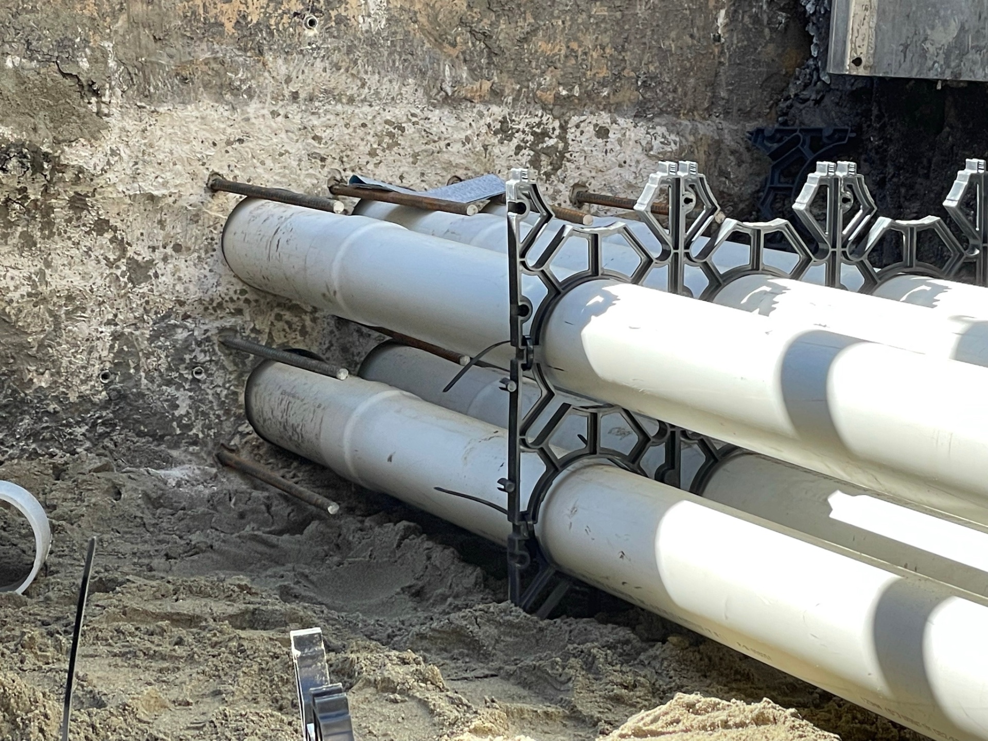 Close-up of stacked PVC ductbank with conduit spacers prepared for concrete encasement