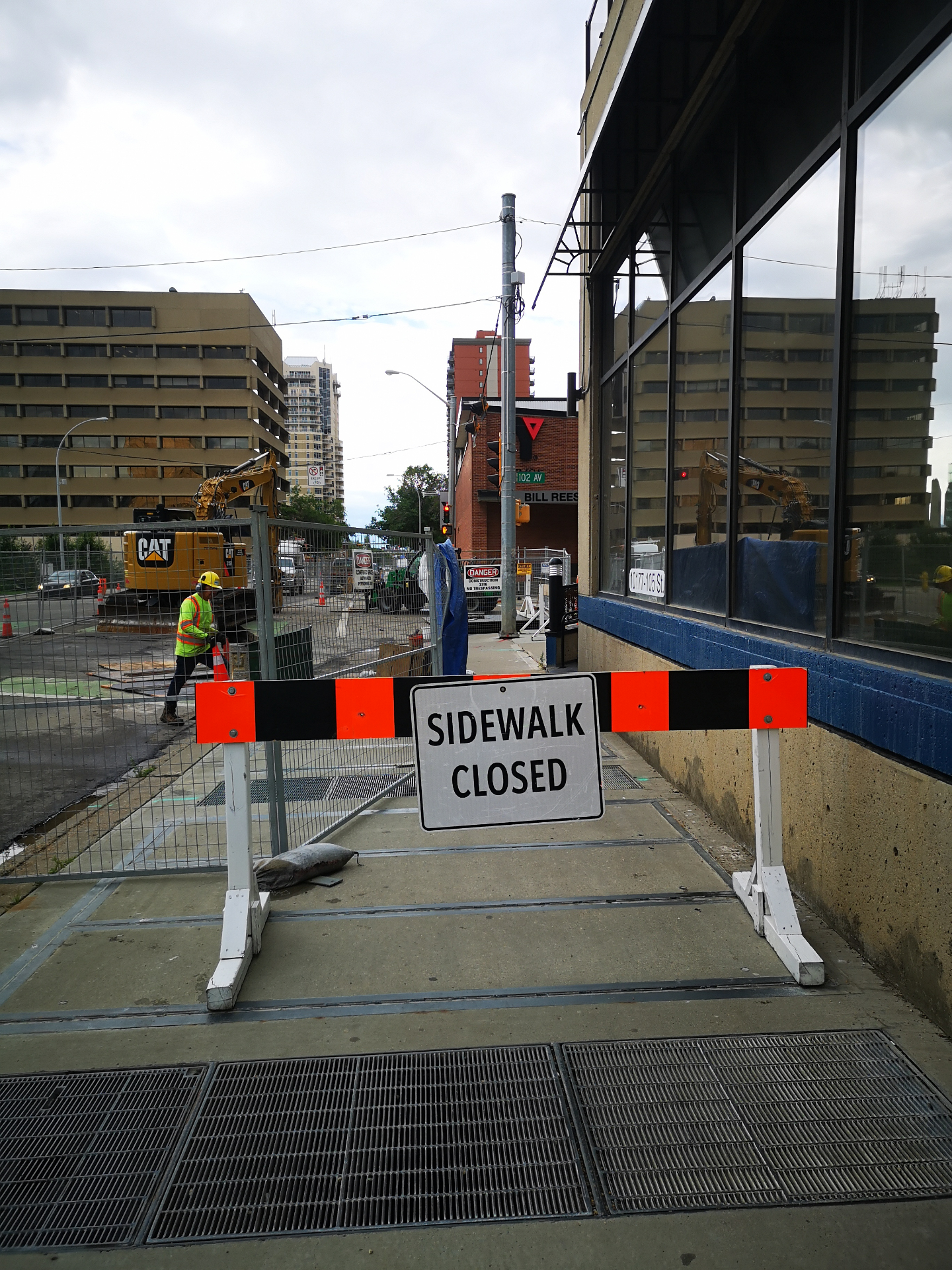 ASI Tech downtown work zone with sidewalk closure and CAT excavator