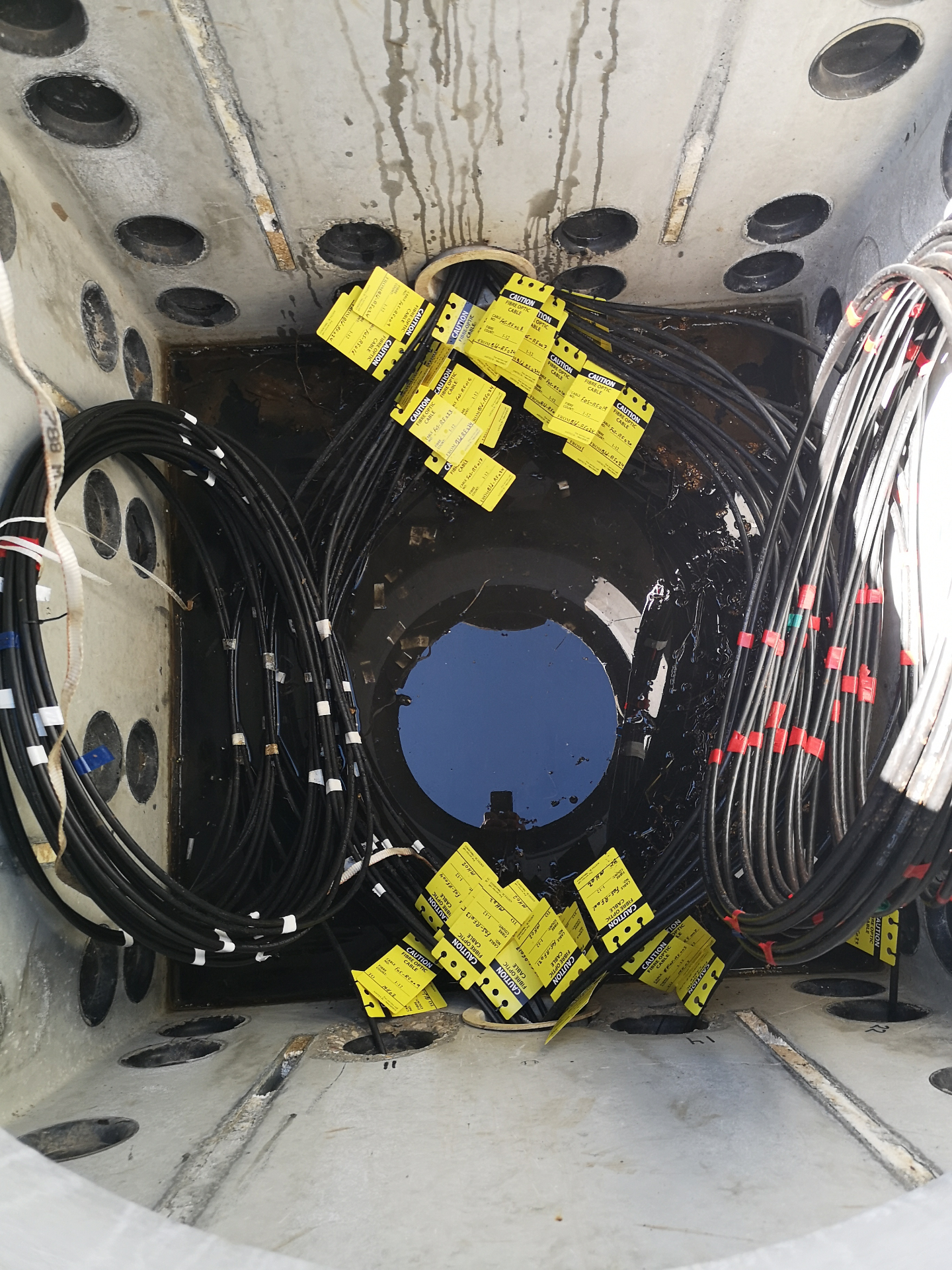 Underground manhole with labeled fiber optic cable coils