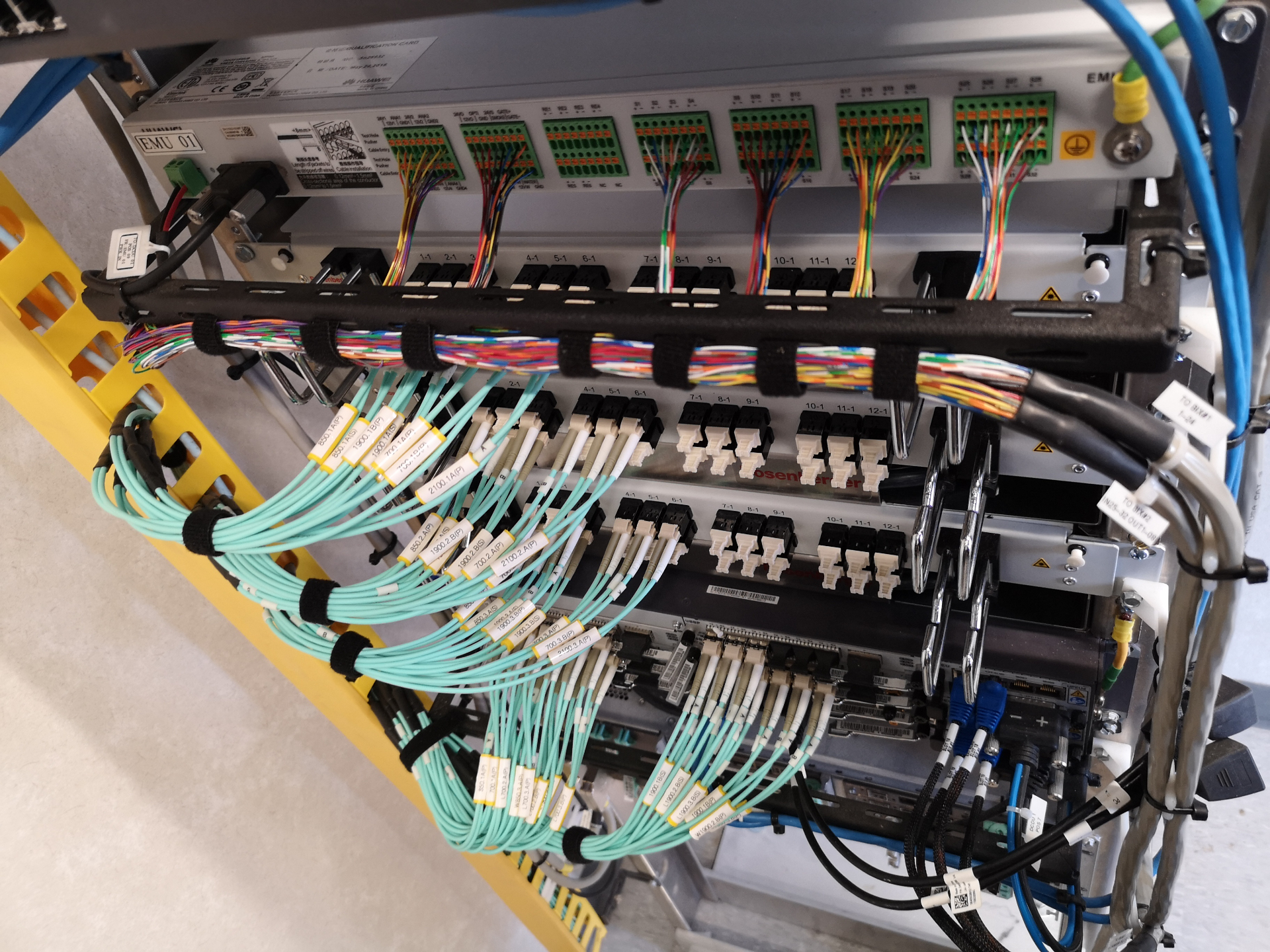 Rack-mounted fiber patch panels with labeled LC jumpers and copper distribution