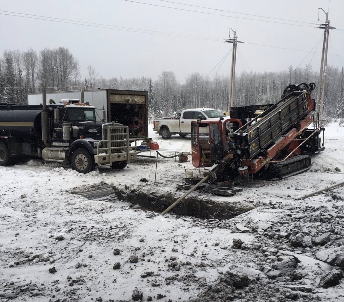 Ditch Witch HDD rig boring in winter conditions with mud truck support