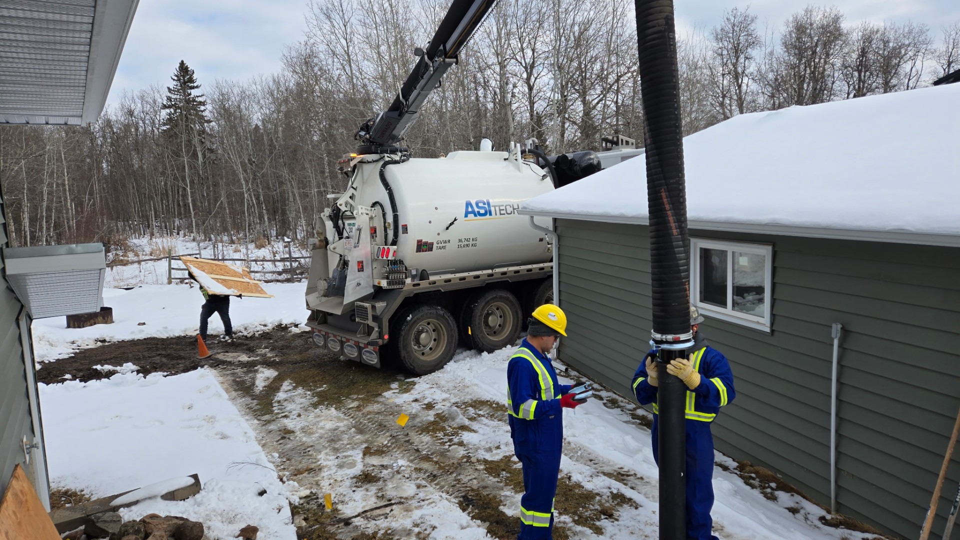 ASI Tech hydrovac crew excavating beside building in winter conditions