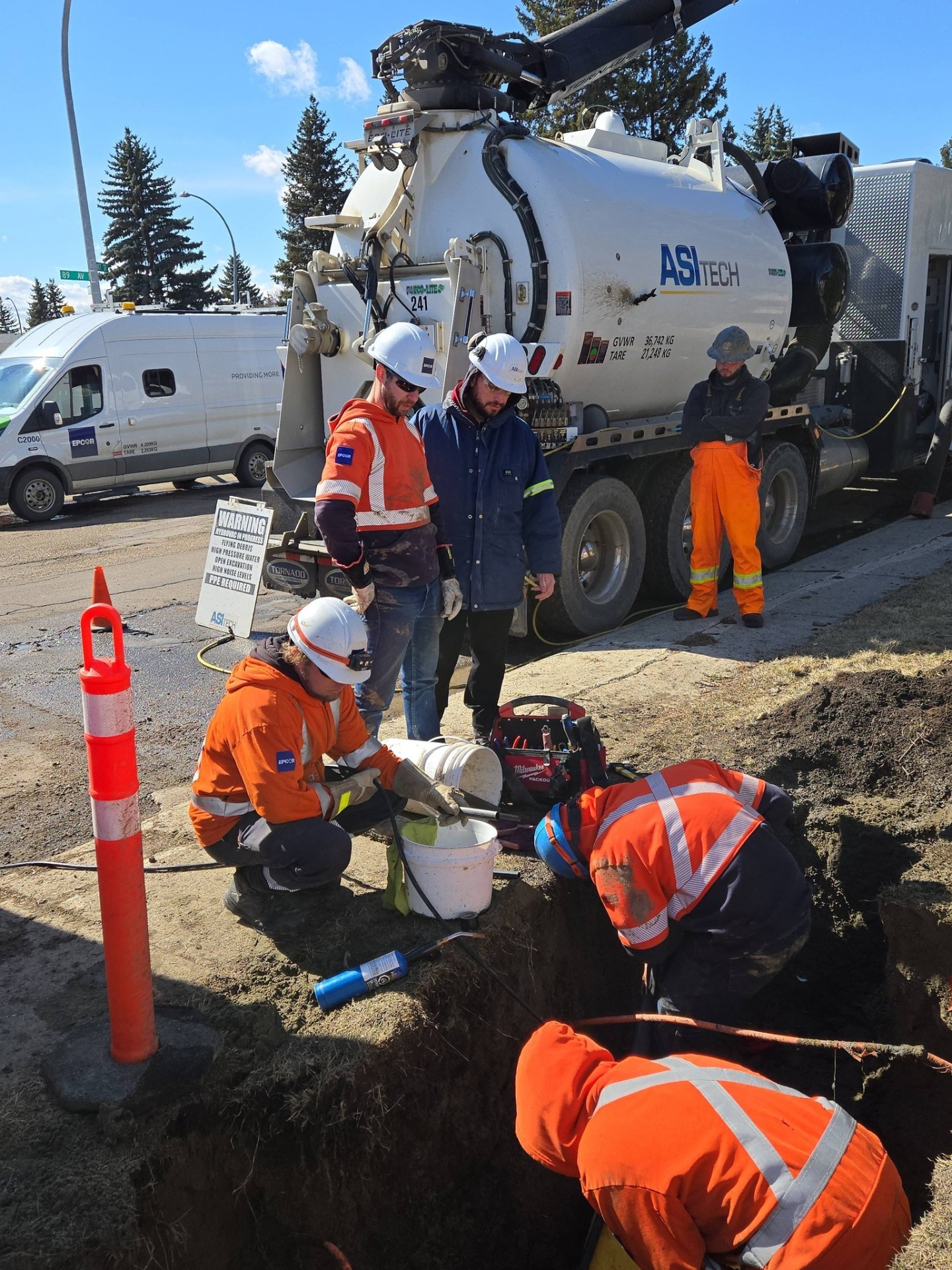 Hydrovac crew exposing underground utilities for EPCOR repair work