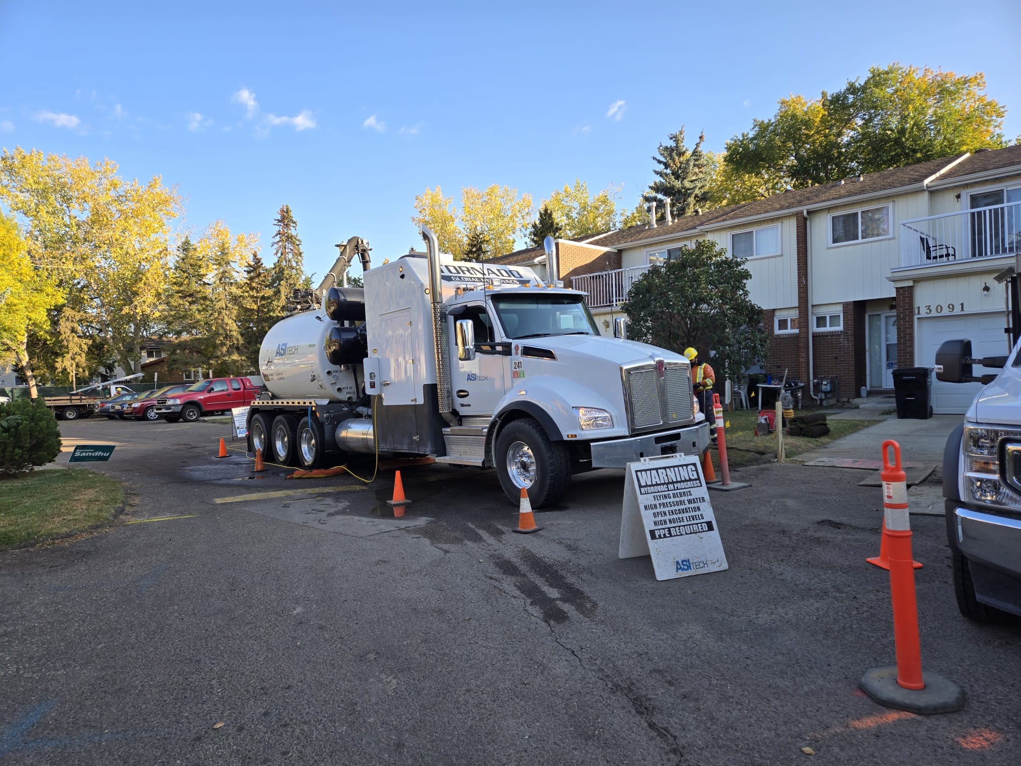 ASI Tech hydrovac truck and support vehicle on residential job site